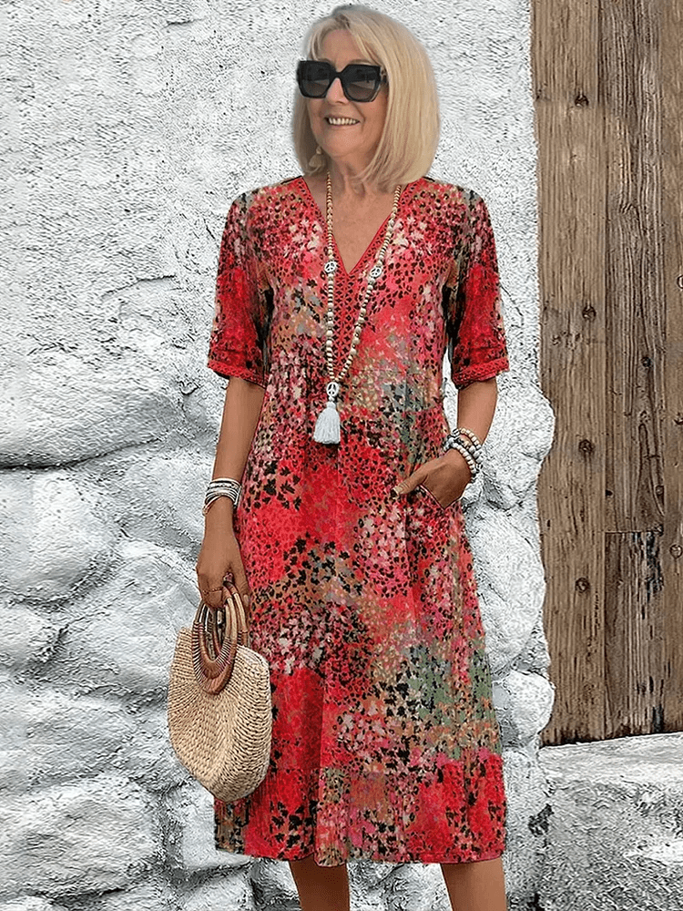 Knee-length V-neck summer dress featuring a vibrant floral pattern and convenient side pockets, designed for comfort in plus sizes. 0